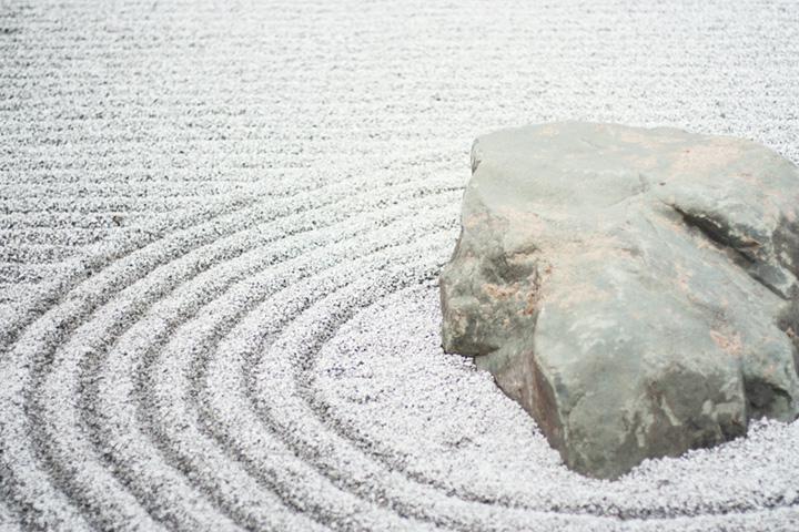 white Zen garden with a large rock and gravel pattern