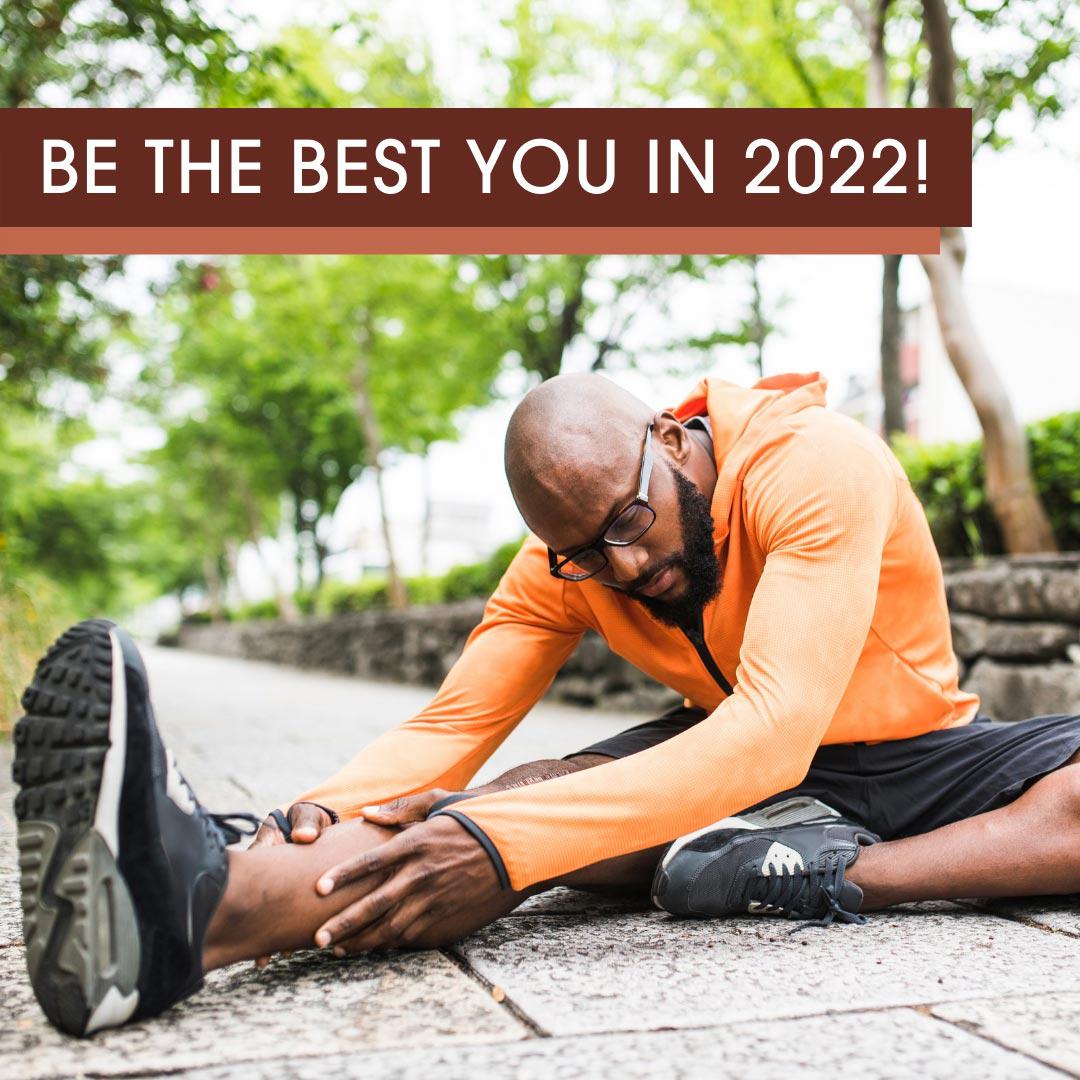 Be the Best You in 2022! A black man prepares for his run by doing leg streches in a community park beforehand.